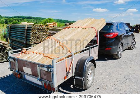 Outdoor Stacking The Logs On Utility Trailer For Transport At Sawmill In Europe With Background Gree