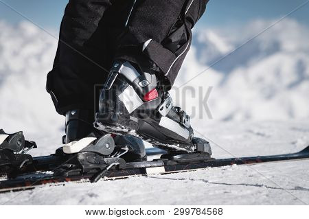 Close-up Of The Athletes Skiers Foot In Ski Boots Rises Into The Skis Against The Background Of The 