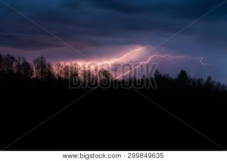 Colourful Summer Thunder Storm Over The Forest At Night. Spectacular Lighting Strikes In The Sky