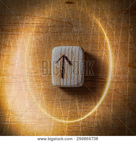 Tiwaz. Handmade Scandinavian Wooden Runes On A Wooden Vintage Background In A Circle Of Light. Conce