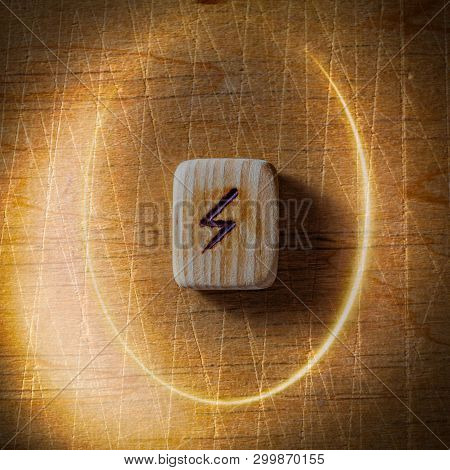 Sowilo. Handmade Scandinavian Wooden Runes On A Wooden Vintage Background In A Circle Of Light. Conc