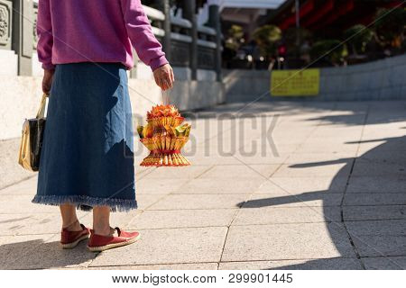 Nantou, Taiwan - FEB 8th, 2019: woman hold a lotus made by joss paper ready for burn at a Baohu Dimu Temple