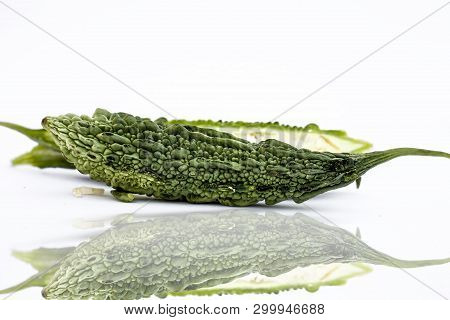 Raw Organic Bitter Melon Or Bitter Cucumber Or Bitter Gourd Isolated On White With Its Reflection.