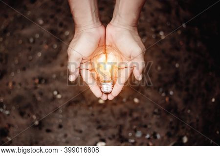 Hand Holding Light Bulb,natural Energy And Love The World Concept.