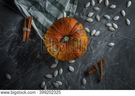 Beautiful Exquisite Small Pumpkin, On A Stone Table, Next To Pumpkin Seeds. Near Striped Towe And Ci