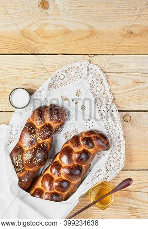 Fresh Homemade Challah With Sesame Seeds On A White Lace Napkin. Honey And Butter On The Table. Top 