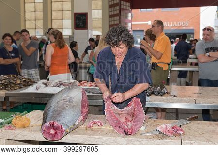 Funchal At Madeira, Portugal - August 01, 2014: Butcher Preparing A Tuna Bij Removing Guts At The Fi