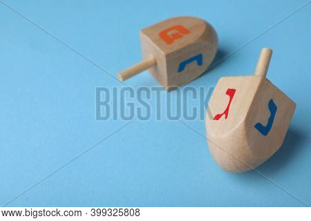 Hanukkah Traditional Dreidels With Letters Gimel, Nun And Pe On Light Blue Background, Space For Tex