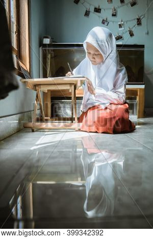 Indonesian Schoolgirl Studying Homework During Her Online Lesson