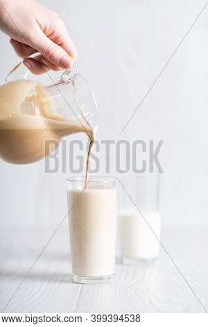 Dalgon Brown Coffee Mixture Is Poured From The Decanter Into A Glass Of Milk. Milkshake With Instant