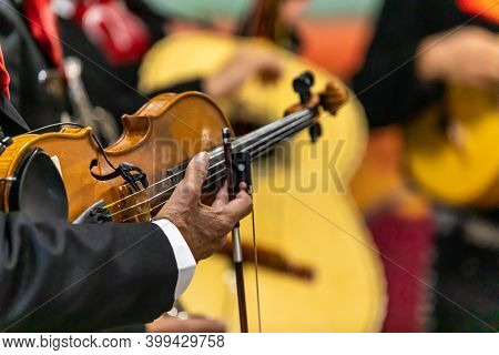 Selective Focus Of Hands Of Senior Man Holding Violin, And Bow Playing Pizzicatos With Orchestra Dur