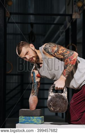Hard-working Armless Man Doing Bent Over Single Arm Back Row With A Kettlebell