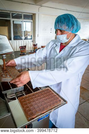 Guaranda, Bolivar / Ecuador - November, 2013: A Worker At A Local Chocolate Factory, In A White Coat