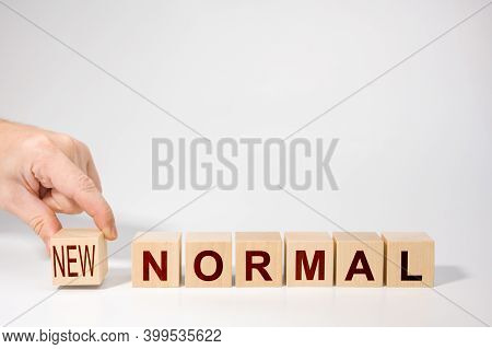 Hand Arranging Wooden Cubes With New Normal Word. Adapting To New Life Or Business Post-lockdown Cor