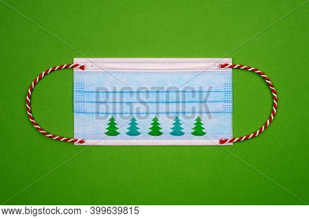 Blue Medical Face Mask With Red And White Christmas Ribbon Instead Of Rubber And Green Christmas Tre