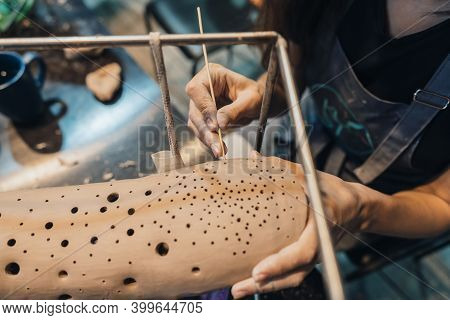 Close-up View Of Female Hands Gently Handling A Clay Whale In Workshop.