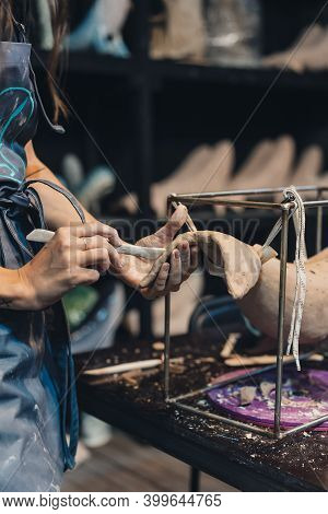 Close-up View Of Female Hands Gently Handling A Clay Whale In Workshop.