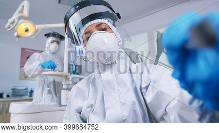 Patient Pov While Dentist In Ppe Suit Against Covid Is Working On Tooth Hygine In Dental Office With