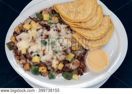 Overhead View Of Alambre Plate Of Grilled Meat, Chopped Vegetables, And Melted Cheese Served With Co