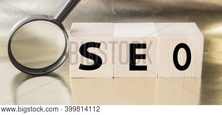 Seo Search Engine Optimization Text Wooden Cubes And Magnifying Glass On A Golden Background. Idea, 