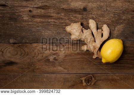 Close Up Of Fresh Ginger Root And Lemon On Wooden Table