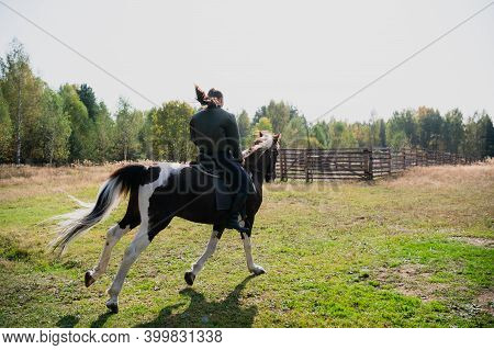 A Young Girl Enjoys The Autumn Nature While Riding A Horse Outside The City.
