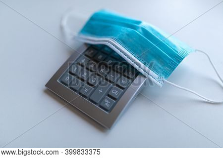 Calculator and face mask - pandemic disease covid19 coronavirus recesion and global financial crisis concept