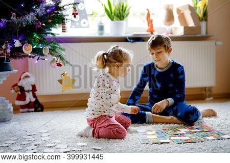 Two Little Chilren, Cute Toddler Girl And School Kid Boy Playing Together Card Game By Decorated Chr