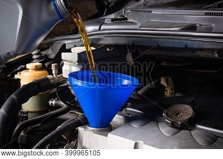 Mechanic In Service To Repair The Car, Refueling And Pouring From Bottle To Change Lubricant Oil At 