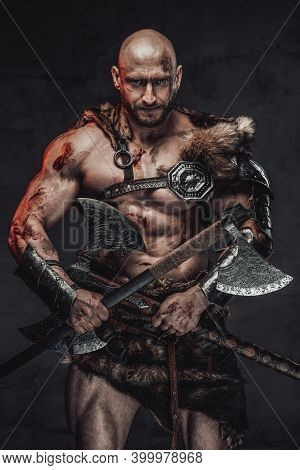 Savage And Skilled Scandinavian Warrior With Bald Head Wielding Two Axes And In Armour With Fur In D