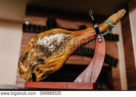 Jamon Serrano. Traditional Spanish Ham Hamon - Whole Leg Of Dried Pork Meat On A Wooden Stand. Bello
