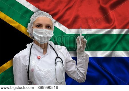 Young Woman Doctor In Medical Uniform On The Background Of The National Flag Of South Africa Is Hold