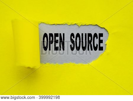 Open Source Text Is Visible Through A Hole In The Yellow Paper, On A Gray Background. A Concept Phot
