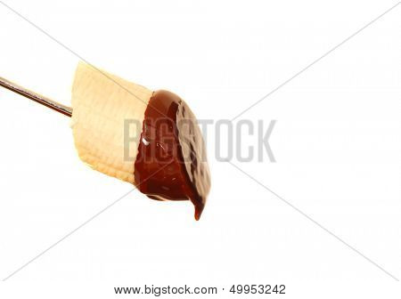 Fresh banana with dark chocolate sauce dripping from it