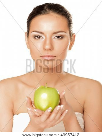 A portrait of beautiful young woman with a green apple on her hand - on white background