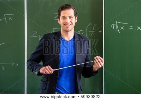 Teacher or docent in school holding a pointer in front of a blackboard in school class