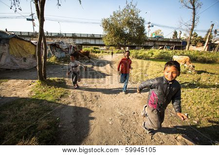 KATHMANDU, NEPAL - DEC 16, 2013: Unidentified poor children near their houses at slums in Tripureshwor district, Kathmandu. Caste of untouchables in Nepal, is about 7 % of population.