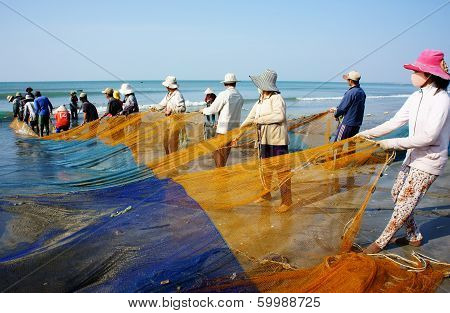 Group Of Fisherman Pull Fish Net
