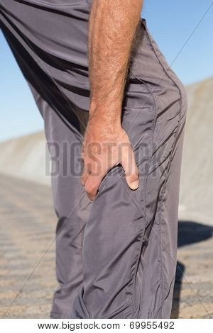 Active senior man touching his injured calf on a sunny day