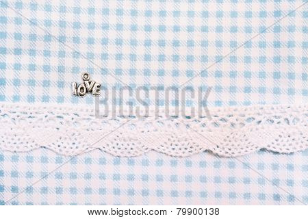 Love sign on blue dogtooth fabric with lace ribbon. Valentine's Day