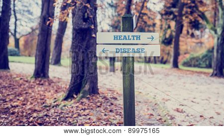 Rustic Wooden Sign In An Autumn Park With The Words Health - Disease