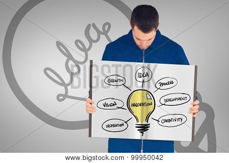 Manual worker showing a book against grey vignette