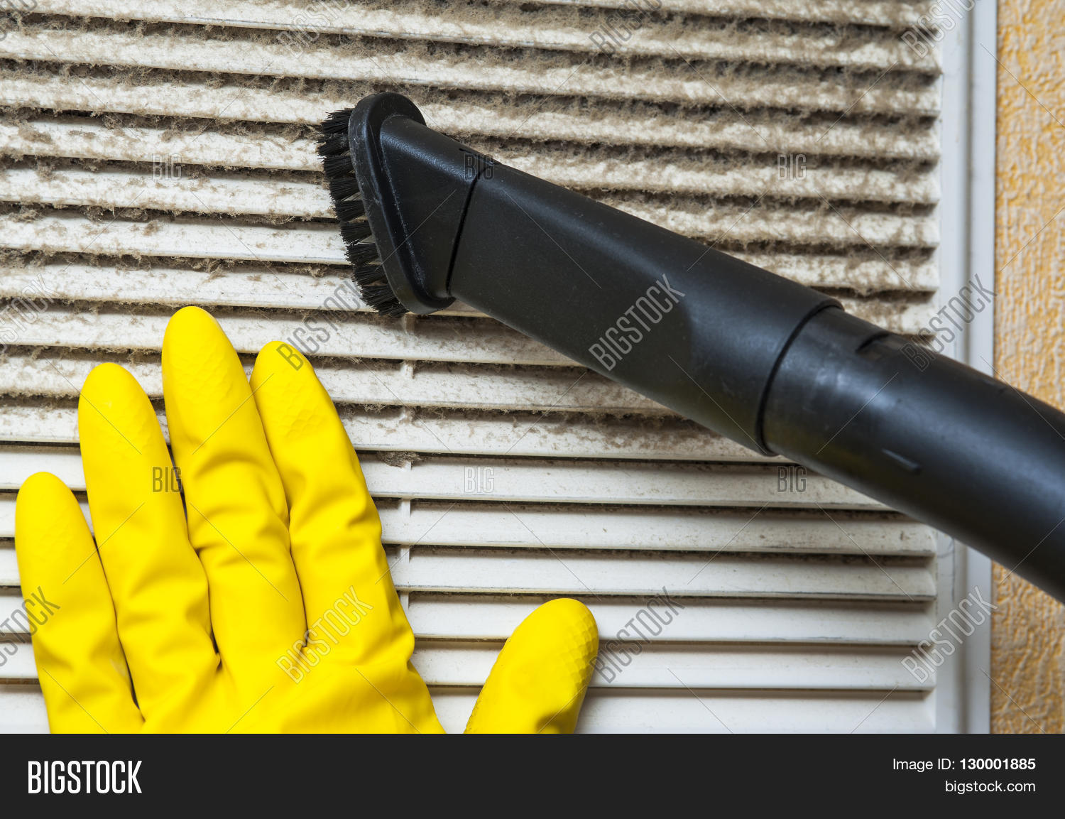 hand in yellow glove and vacuum cleaner pipe.