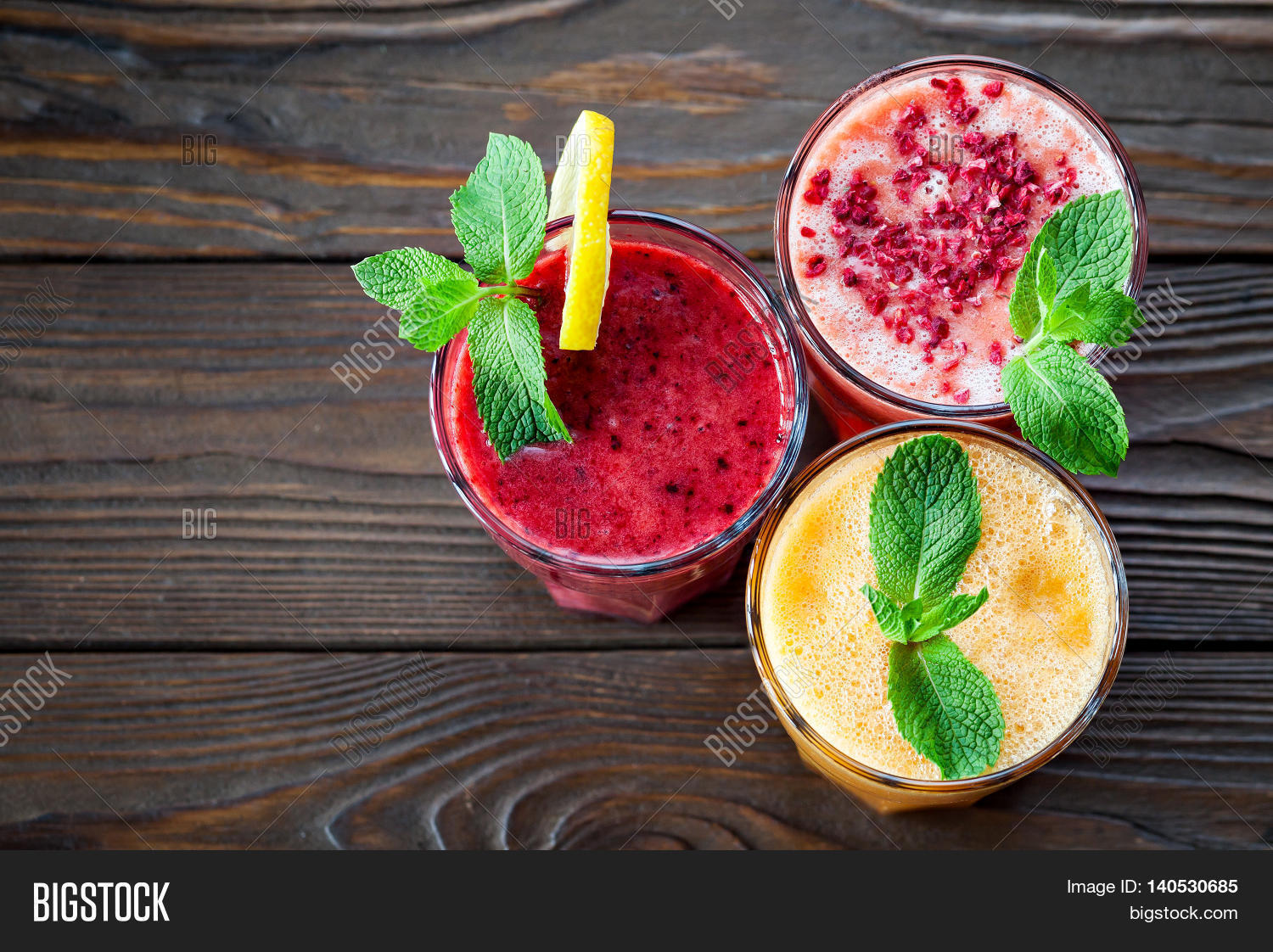assorted fruit smoothies on a wooden table. smoothie concept