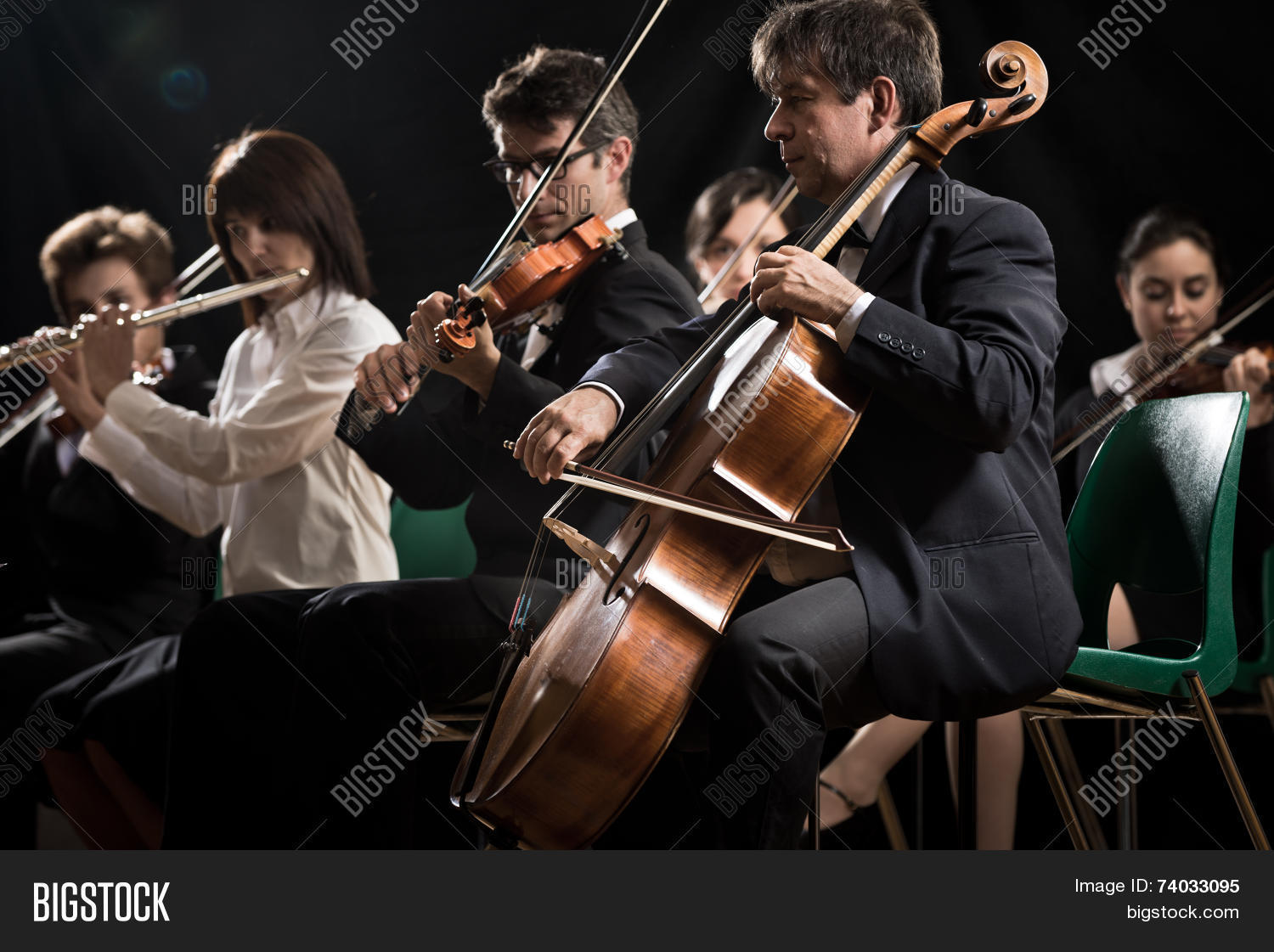 symphony orchestra on stage violins cello and flute performing.