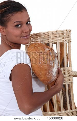 她怀里抱着面包的年轻黑人女性