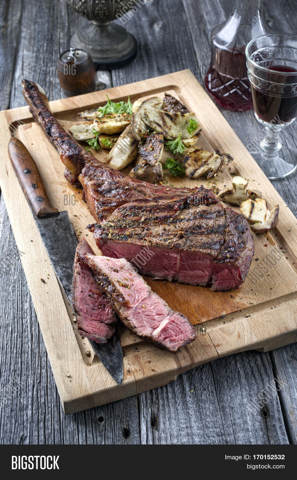 barbecue tomahawk steak with mushrooms on cutting board