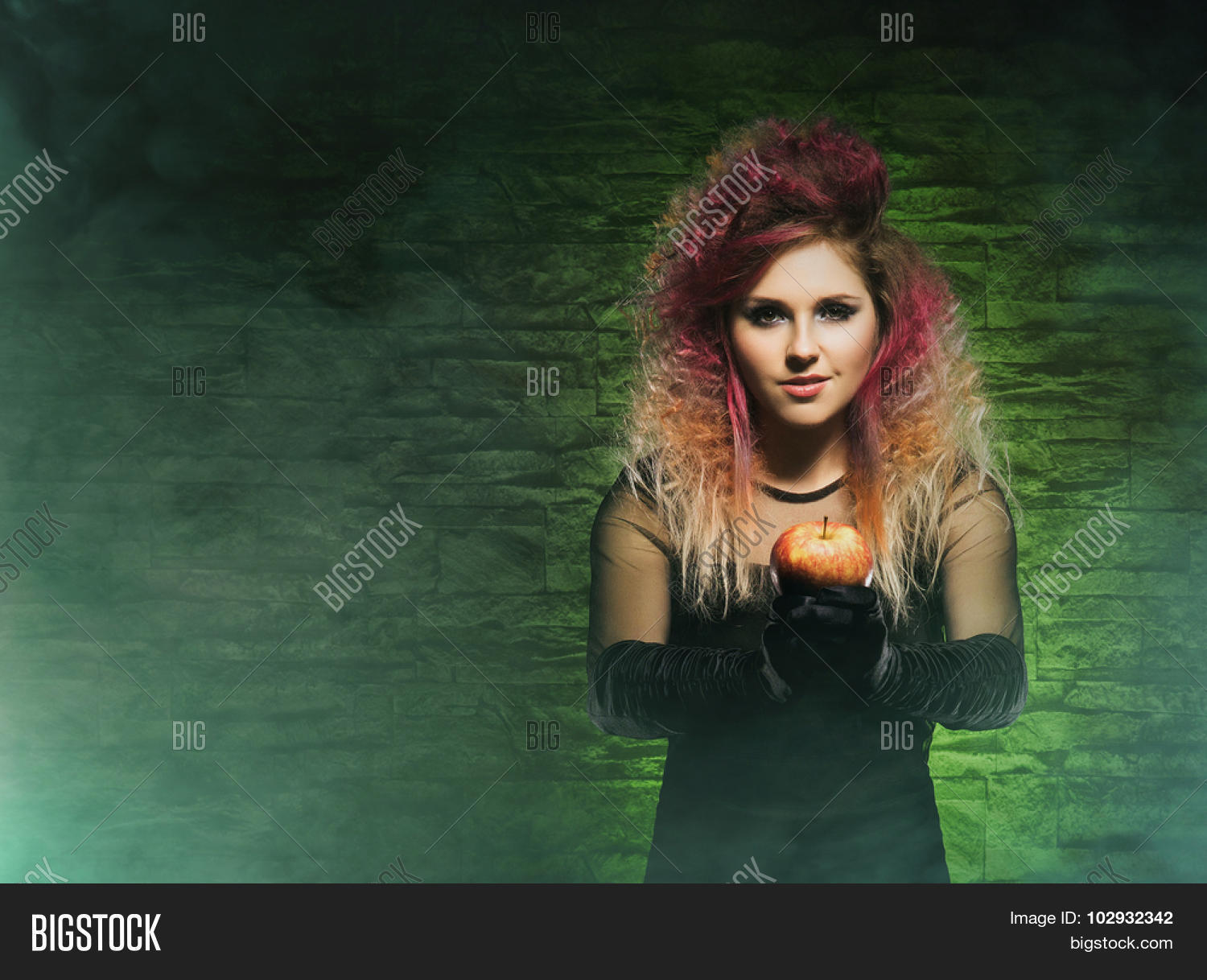 beautiful witch giving an intoxicate apple. halloween concept.