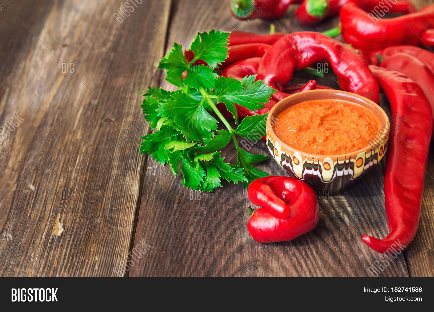 homemade sauce and red hot chili peppers and celery on rustic