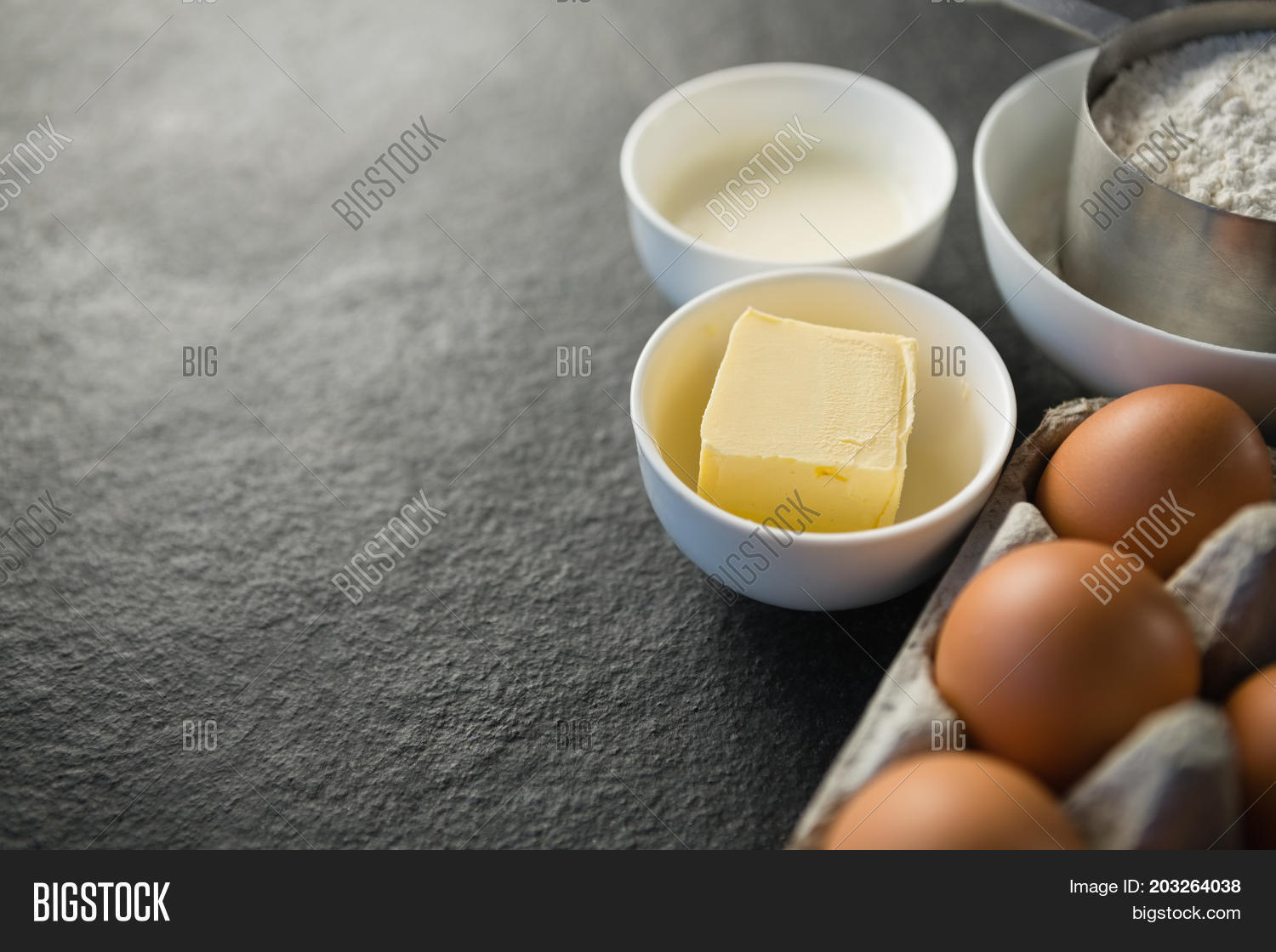 close up of egg carton by butter in bowl on tbale